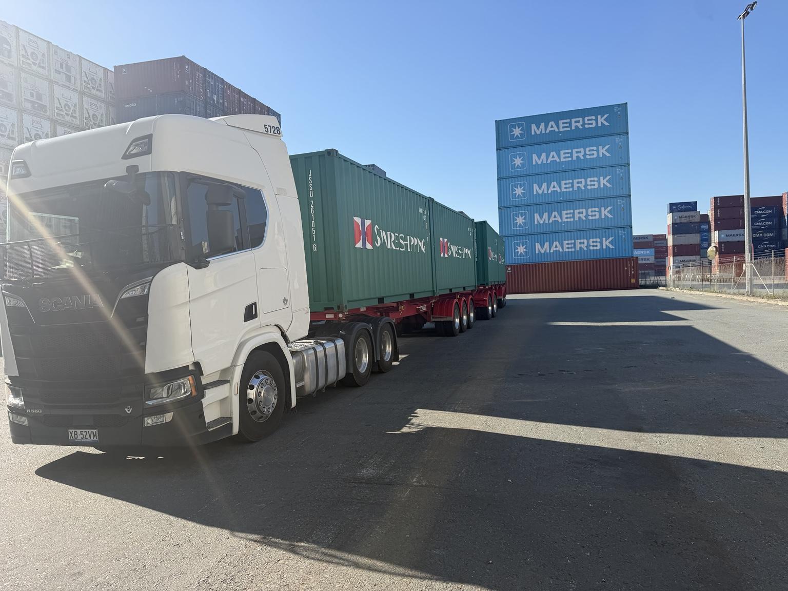 CCE Express Scania prime mover hauling shipping containers through a Brisbane container yard